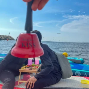 Personas disfrutando picnic y paddleboard en el mar
